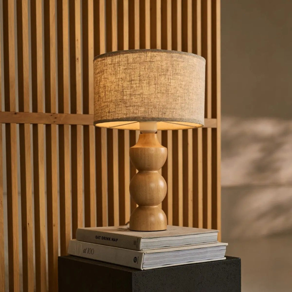 Oliver corded lamp side view showing rubberwood base and linen shade