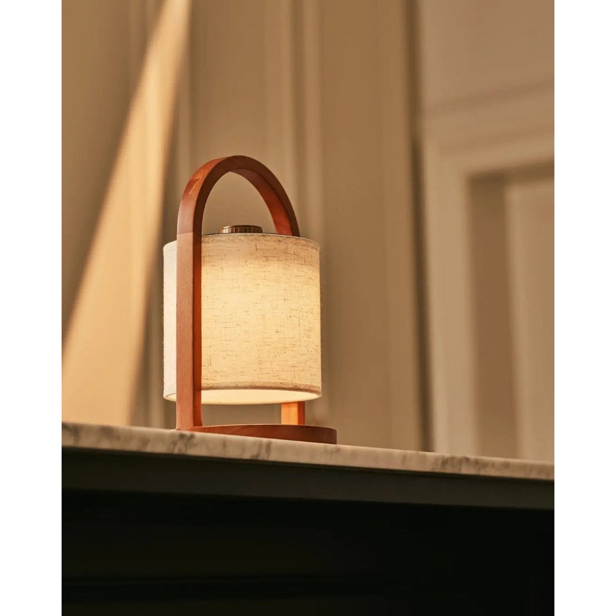 Elor cordless lamp side view showing rubberwood base and linen shade