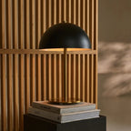 Lola corded lamp side view showing black and gold metal form