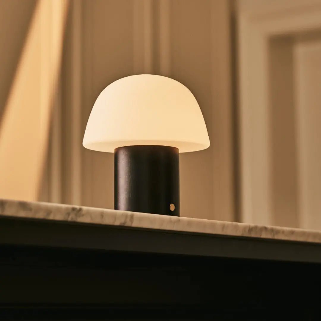 Yannick cordless lamp side view showing rubberwood base and frosted shade