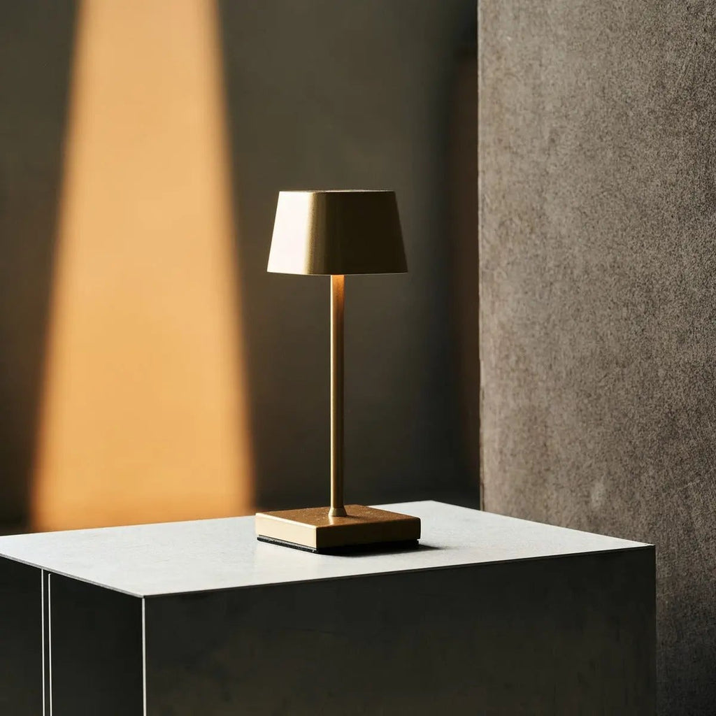Sarphati gold rechargeable lamp on bedside table