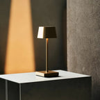 Sarphati gold rechargeable lamp on bedside table