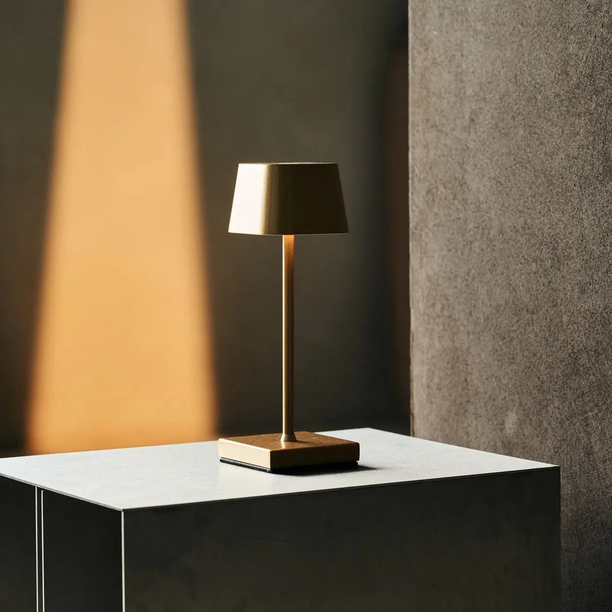 Sarphati gold rechargeable lamp on bedside table