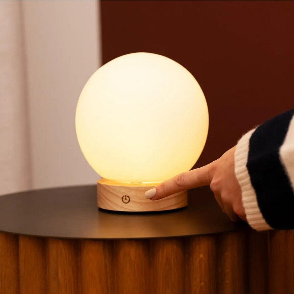 Flore cordless lamp side view showing rubberwood and matte glass shade