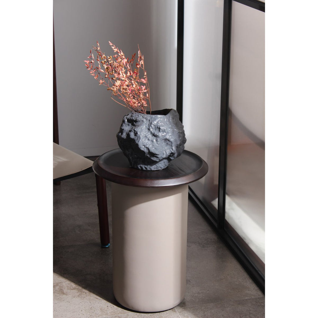 Modern side table with a decorative rock and branches on a neutral background