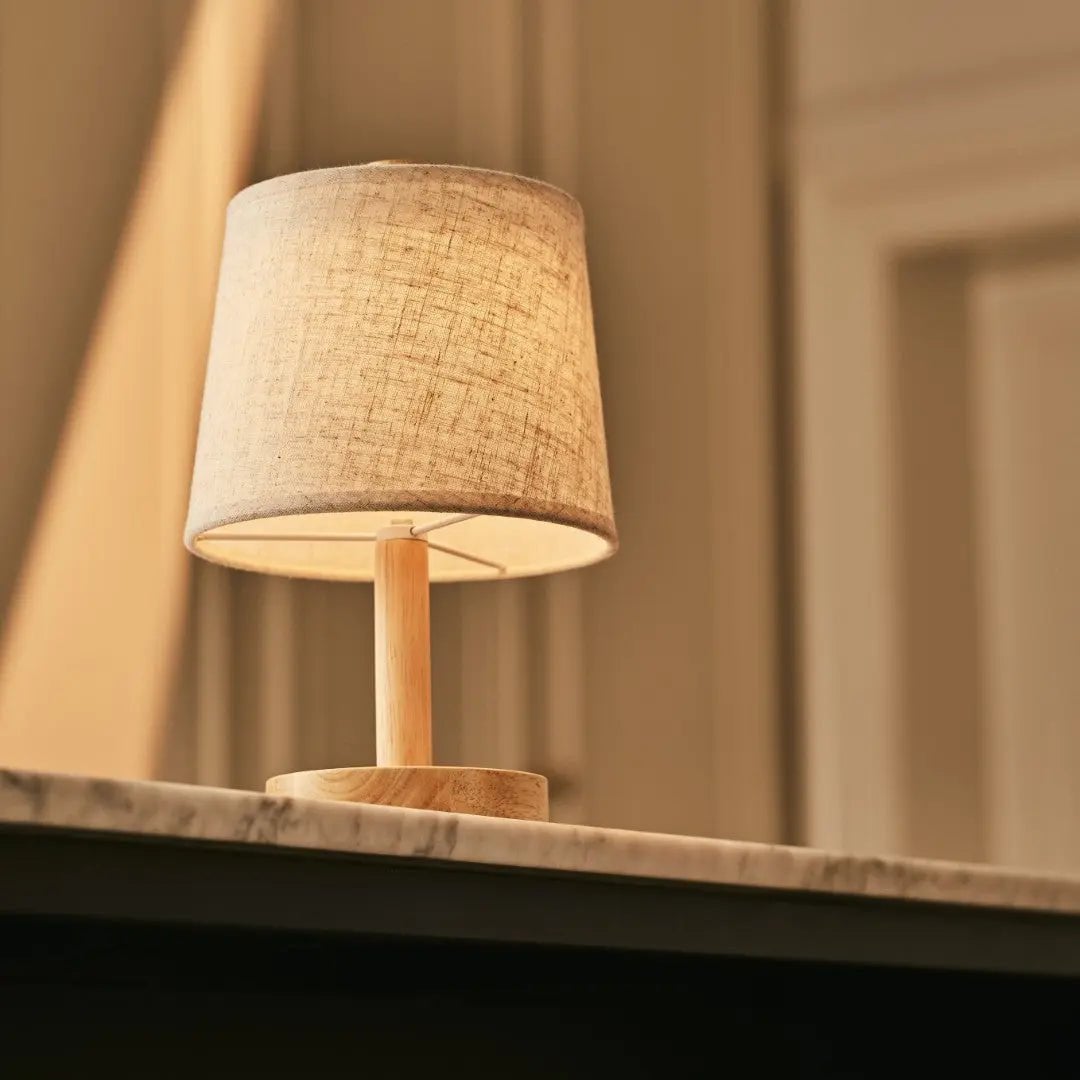 Ciro cordless lamp side view showing rubberwood base and linen shade
