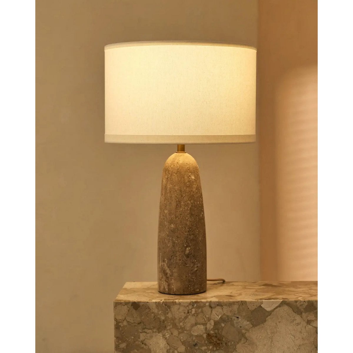 Serena corded lamp side view showing travertine base and cotton shade