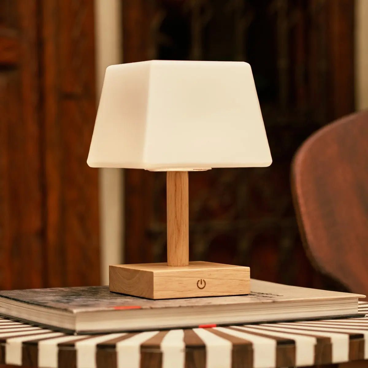 Tommy cordless lamp side view showing rubberwood base and glass shade