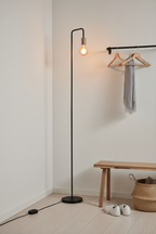 Modo black floor lamp in hallway corner beside coat rack and wooden bench