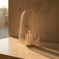 Stoense beige metal lantern on travertine shelf, golden light casting shadow lines