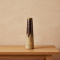 Terra brown ceramic sculptural vase on oak console, limewash wall, natural light