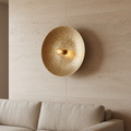 Volle Maan Brass Wall Lamp in woonkamer naast linnen bank