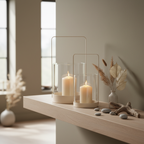 Set of two beige glass and metal hurricane candle holders on a sideboard in a Nordic interior with dried botanicals