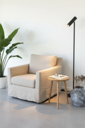 Paris floor lamp with spotlight head angled toward linen reading chair