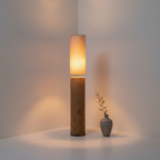 Totem Mud Floor Lamp staand in hoek tussen witte pleistermuren