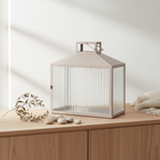 Lucca beige grey metal glass lantern on a mantelpiece in a Nordic interior with dried botanical styling