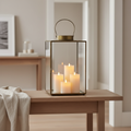 Mohali large antique brass metal and glass lantern styled on a Scandinavian console with warm candlelight