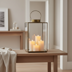 Mohali large antique brass metal and glass lantern styled on a Scandinavian console with warm candlelight