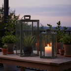 Set of two Corfu green steel glass lanterns on a sheltered terrace at dusk with warm candlelight and potted plants