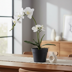 Realistic artificial white orchid plant on a dining table in a warm Nordic interior with linen runner