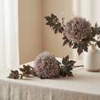 Faux natural bouquet loosely arranged on linen surface with warm neutral background and soft natural light