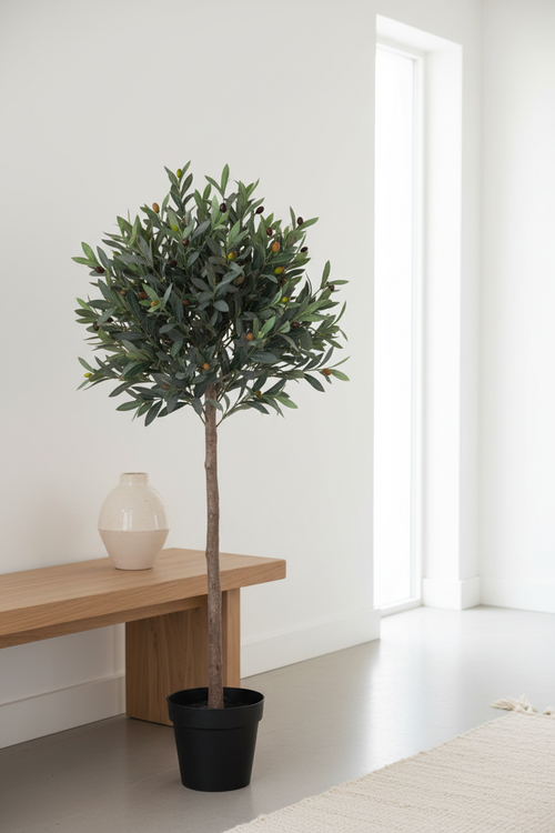 Artificial olive tree in hallway entryway beside wooden console with ceramic vase
