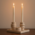 Luma travertine tealight holder set extreme close-up, walnut surface, candlelight