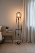 Stelo smoked glass globe floor lamp in bedroom corner with warm filament glow