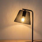 Korie lamp close-up detail of black wire mesh shade with warm filament bulb glow