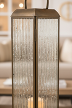 Close-up of Herslev lantern antique brass frame and glass panel with warm candlelight glow
