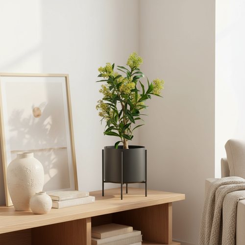 Realistic artificial Skimmia plant with green leaves and red flower buds styled in a Scandinavian living room corner