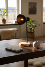 Marie black metal desk lamp with wood base on dark oak desk with linen notebook
