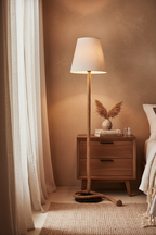 Touw rope floor lamp in bedroom corner beside wooden nightstand and linen curtain