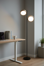 Tessa dual-head LED floor lamp beside standing desk with books and ceramic mug