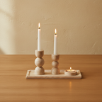 Luma travertine tealight holder set on oak dining table, limewash wall, lit candles