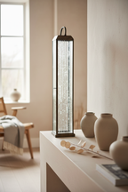 Herslev tall antique brass glass lantern on a windowsill in a Nordic interior with dried botanical styling