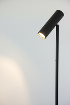 Close-up of Paris matte black cylindrical adjustable spotlight head on steel pole