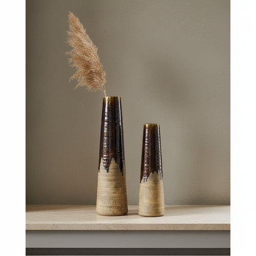 Earthline brown ceramic vase set on travertine shelf, concrete wall, dried branch