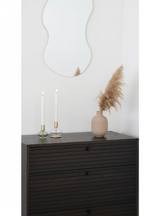Lumis Duo candle holders styled on a dark sideboard with wavy mirror