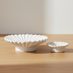 Set of two white cement candle holders on oak surface with soft daylight and clean off-white background