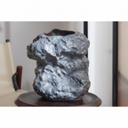 Close-up of black ceramic vase surface texture mimicking natural rock with warm ambient light